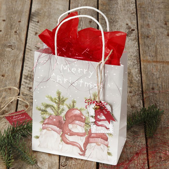Christmas gift wrapping with a gift bag and gift tag with a bell