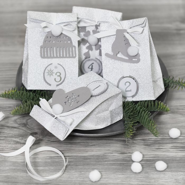 Adventskalender cadeautjes versierd met papieren versieringen en pompons