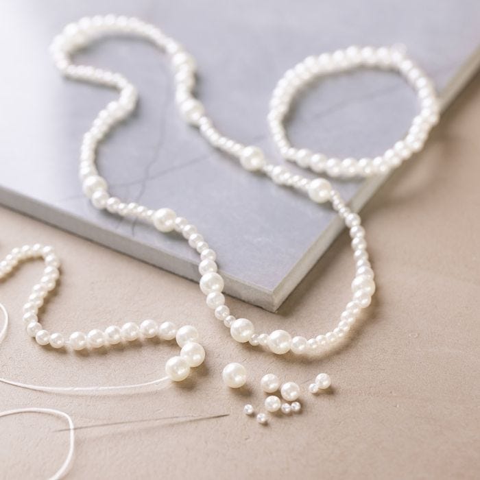 Halsketting en armband met parelmoerwitte kralen