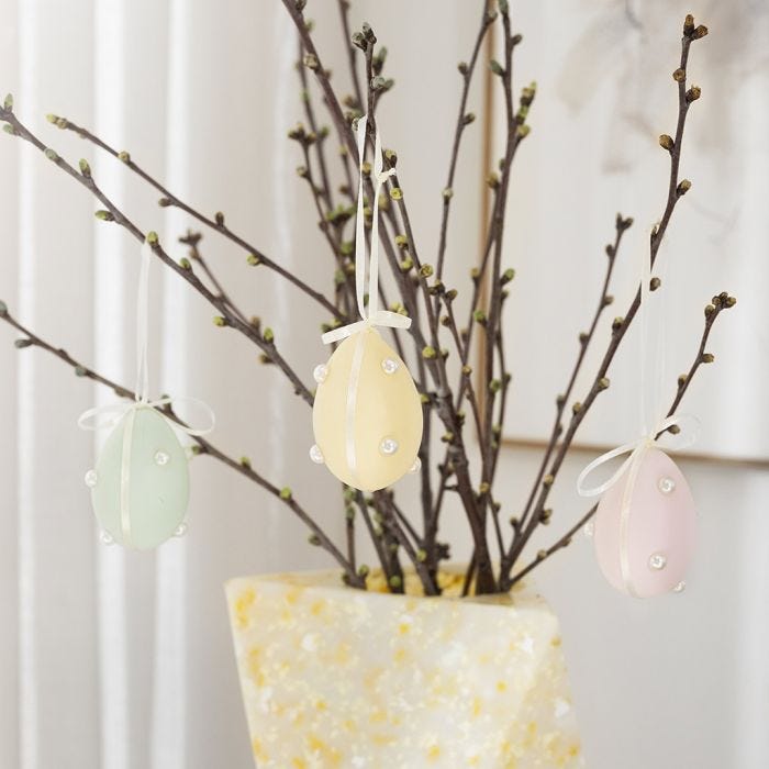 Pastel eieren met halve kralen en satijnlint
