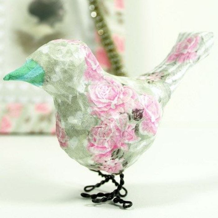 Een vogel met decoupage en poten van bloemendraad