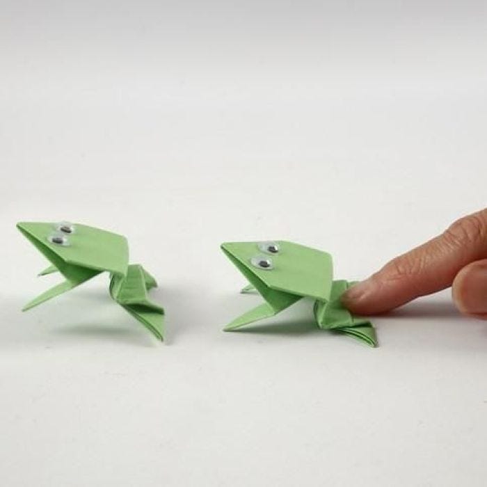 Een origami kikker met wiebelogen