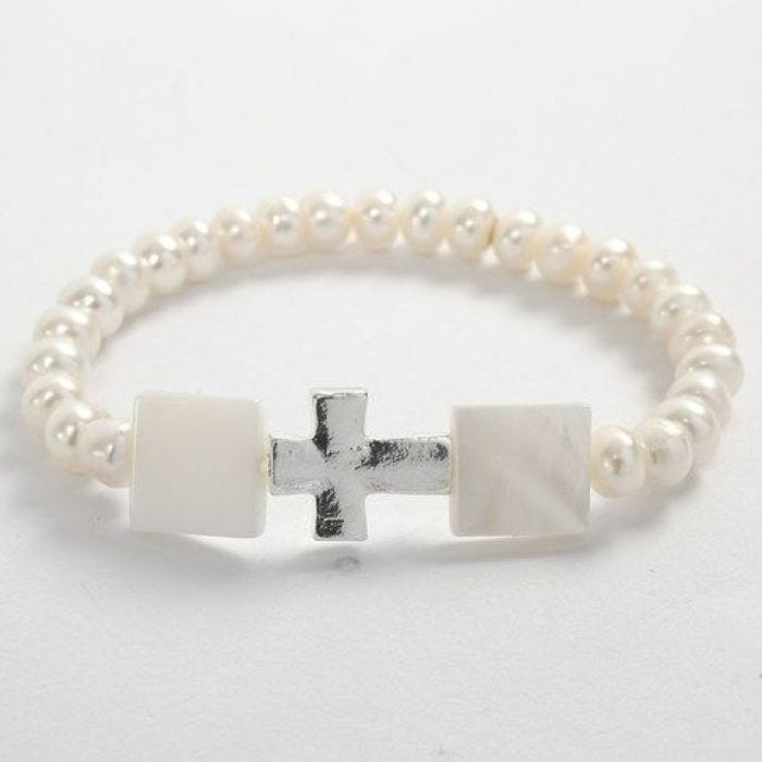 Een elastische armband met witte kralen en een kruis