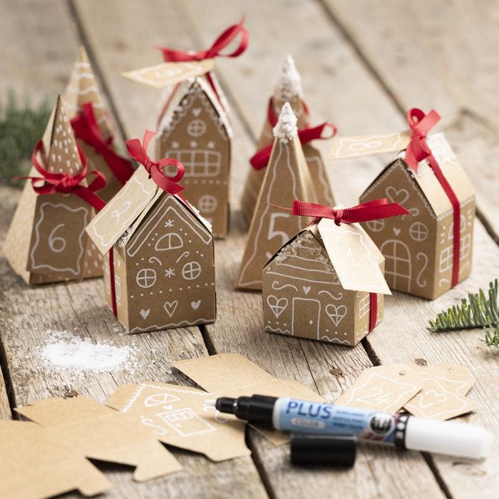 Een adventskalender van 24 kleine huisjes en bomen van papier-maché