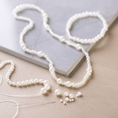 Halsketting en armband met parelmoerwitte kralen