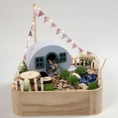 Een miniatuur camping op een dienblad