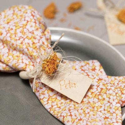 Servetten van patchworkstof en een servetring versierd met gedroogde bloemen