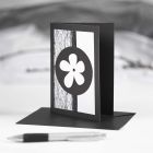 Een zwarte wenskaart met zwarte en witte decoraties