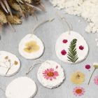 Hangende decoraties van papier-maché pulp versierd met gedroogde bloemen
