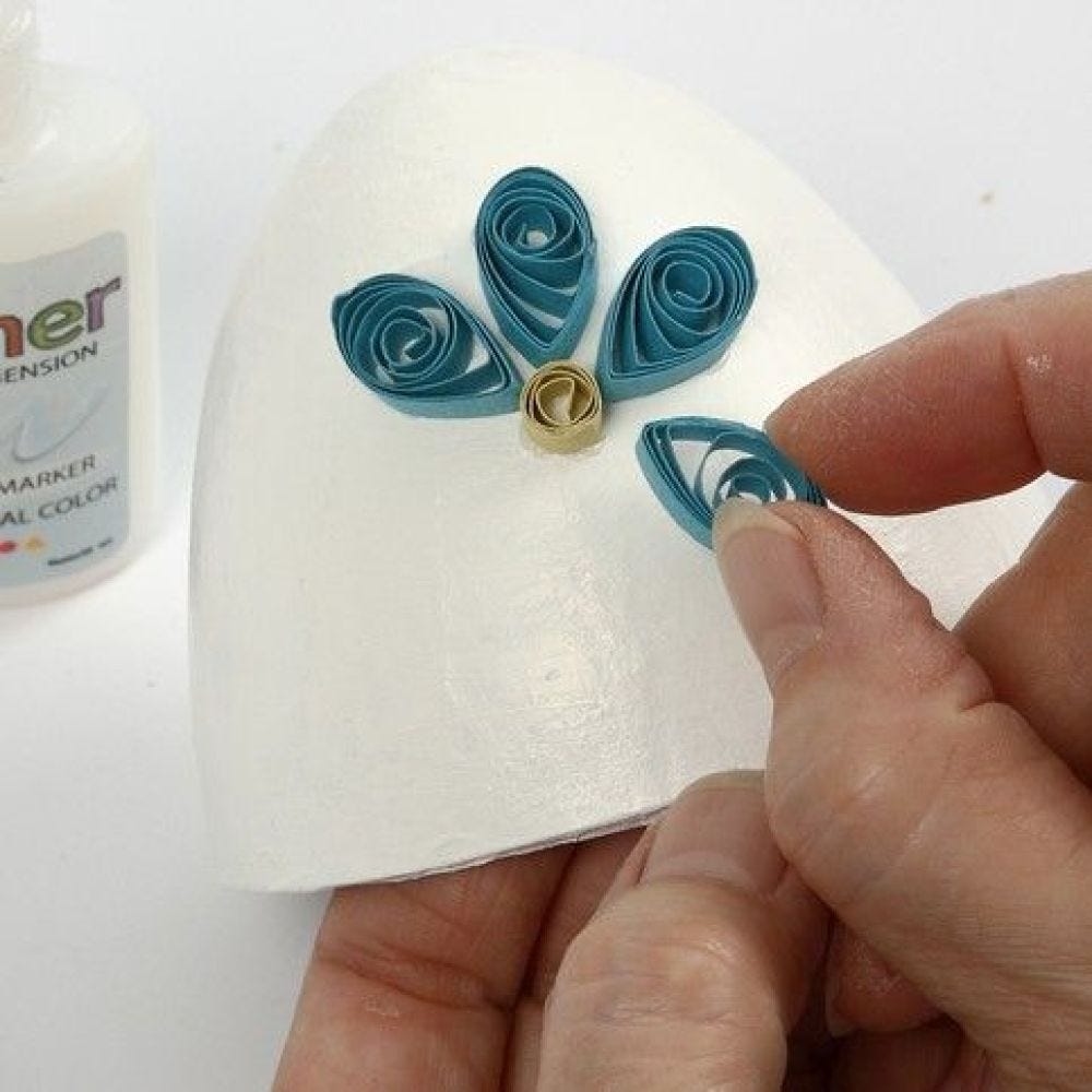 Papier-mâché ei gedecoreerd met quilling